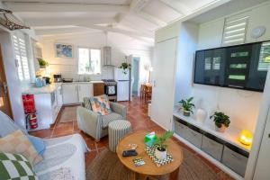 a living room with a table and a kitchen at The Lotus Cottage Maleny in Witta