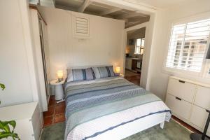 a bedroom with a bed with two lamps on it at The Lotus Cottage Maleny in Witta