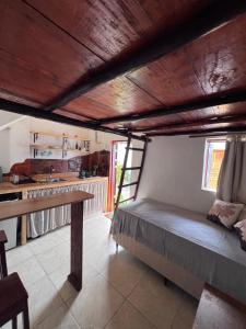 a room with a bed and a kitchen with a table at Casa Ametista in Lençóis