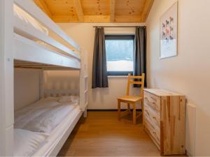 a bedroom with a bunk bed and a chair and a desk at Obermöschach 5A in Obermöschach