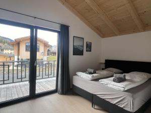 two beds in a room with a large window at Sauna Chalet 9B in Obermöschach