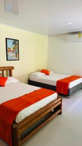 a bedroom with two beds with red sheets at WAYANAY TAYRONA ECO HOSTEL in El Zaino +69 photos