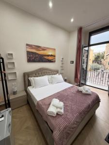 a bedroom with a bed with two towels on it at HV Carbonara 123 in Naples