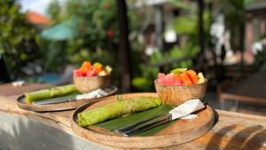 two plates of vegetables and fruit in cups on a table at PGS HOME STAY in Ubud