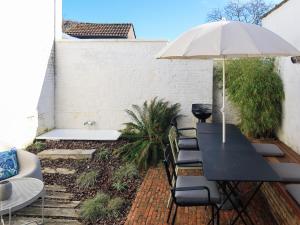 a table and chairs with an umbrella on a patio at Cosy Courtyard House Hasselt in Hasselt