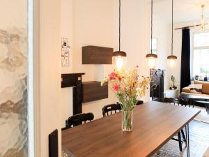 a dining room table with a vase of flowers on it at Cosy Courtyard House Hasselt in Hasselt