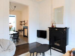 a living room with a fireplace and a tv at Cosy Courtyard House Hasselt in Hasselt