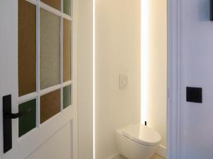 a white bathroom with a toilet and a door at Cosy Courtyard House Hasselt in Hasselt +26 photos