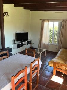 a bedroom with a bed and a tv and a couch at La Calma Casa Quinta in Tandil