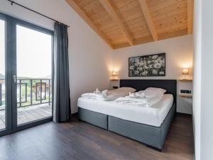 a bedroom with a large bed and a large window at Obermöschach 6A in Obermöschach