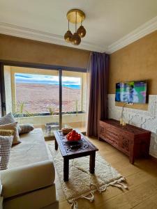a living room with a couch and a table and a tv at Ksar Sultan Dades - Dades Valley Retreat in Boumalne Dades