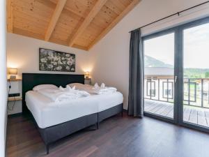 a bedroom with a large bed and a large window at Obermöschach 6B in Obermöschach