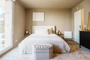 a bedroom with a large bed and a window at Confort et élégance proche centre in Schiltigheim
