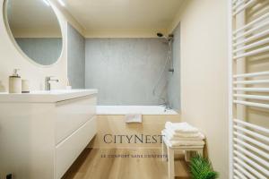 a bathroom with a sink and a mirror at Confort et élégance proche centre in Schiltigheim +6 photos