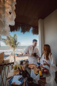 a man and a woman sitting at a table with food at Ankura Preá Spa & Boutique Hotel in Cruz