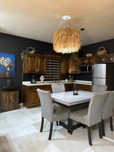 a kitchen with a table and chairs and a chandelier at Ancla Suites in Puerto Peñasco