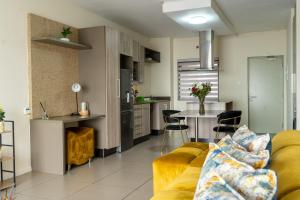 a living room with a yellow couch and a kitchen at Ngalufuno-wlove in Johannesburg