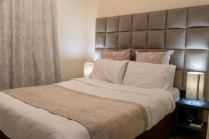 a bedroom with a large bed with a large headboard at Ngalufuno-wlove in Johannesburg