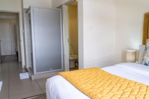 a bedroom with a bed and a bathroom with a toilet at Ngalufuno-wlove in Johannesburg