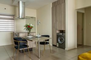 a kitchen with a table and chairs and a washing machine at Ngalufuno-wlove in Johannesburg