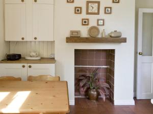 a kitchen with a table and a fireplace at Peasholm in Thornton Dale