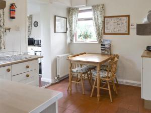 a kitchen with a table and chairs and a window at Peasholm in Thornton Dale