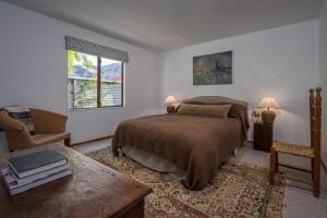 a bedroom with a bed and a table and a chair at Stone Street Cottage by Sothebys Luxury Rental Homes in Wanaka