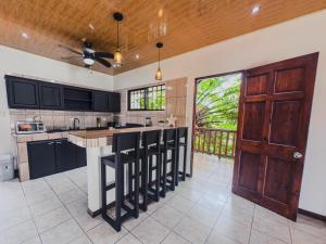 a kitchen with black cabinets and a wooden door at Casa escondida in Uvita