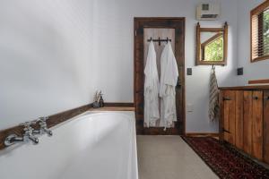 a bath tub in a bathroom with a wooden door at Stone Street Cottage by Sothebys Luxury Rental Homes in Wanaka +11 photos