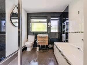 a bathroom with a tub and a toilet and a sink at Mylnebeck Lodge in Windermere +17 photos