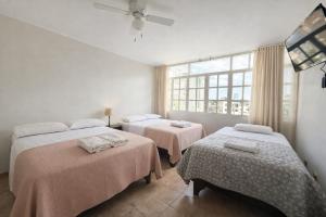 a bedroom with two beds and a flat screen tv at Huacachina Boutique Hotel in Ica