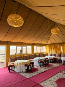 a tent with tables and chairs in a room at Le Pacha Luxury Desert Camp - Mhamid Sahara Activities in Mhamid