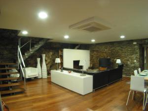 a living room with a couch and a table and a tv at Quinta dos Castanheiros - Turismo Rural in Negreda
