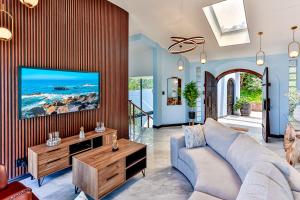 a living room with a couch and a tv at Villa Belle Mere Boutique Hotel in Sheffield Beach