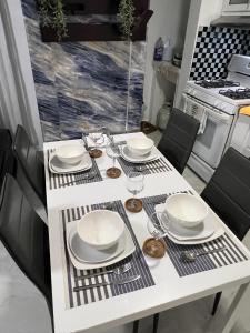 a white table with plates and glasses on it at Residencial christall ap 2-A in Santiago de los Caballeros +11 photos