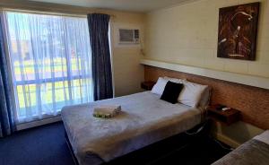 a hotel room with a bed and a window at Dartmoor Hotel Motel in Dartmoor