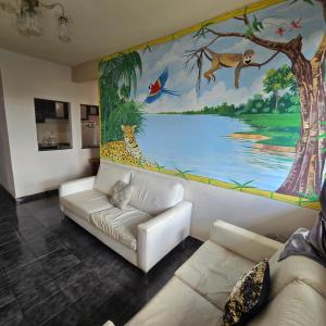 a living room with a couch and a painting on the wall at Apto 1,5 km do Shop. Manauara in Manaus