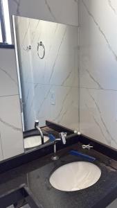 a bathroom with a sink and a large mirror at SSP Ubajara in Ubajara