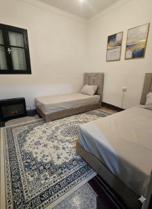 a bedroom with two beds and a fireplace in it at Appartement 3S in Meknès