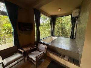 a room with two chairs and a large window at Forest Shade Eco Resort Deraniyagala in Deraniyagala