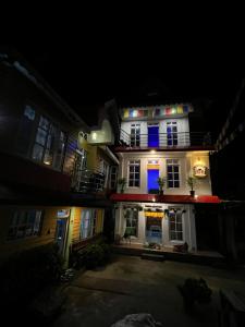 a white house with blue lights on it at night at Jojos homestay in Mirik