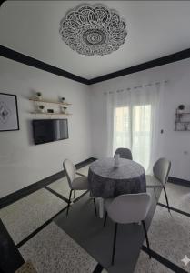 a dining room with a table and chairs and a television at Appartement 3S in Meknès