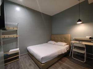 a small bedroom with a bed and a desk at Mirani Hotel Ampang Near Melawati Mall in Kuala Lumpur