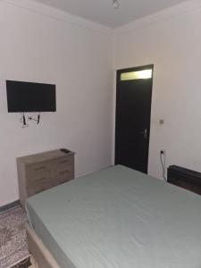 a bedroom with a bed and a flat screen tv at Appartement 3S in Meknès