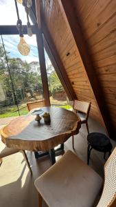 a wooden table and chairs in a room with a large window at Cabana de Vidro - Canelinha in Canelinha