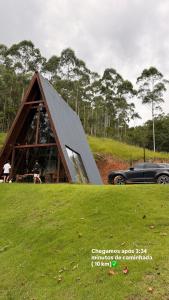 a car is parked in front of a house at Cabana de Vidro - Canelinha in Canelinha