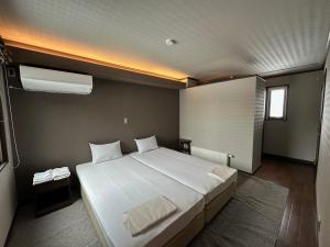 a bedroom with a large white bed and a window at Chalet Yutaka in Furano