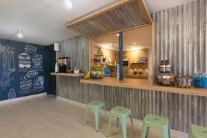 a fast food restaurant with green stools in front of a counter at Summercamp in Oak Bluffs