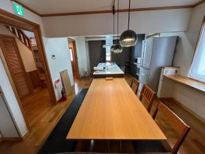 a kitchen with a wooden table and a refrigerator at Chalet Yutaka in Furano