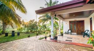 a house with a courtyard with a patio at Paddy Breeze Homestay in Sigiriya